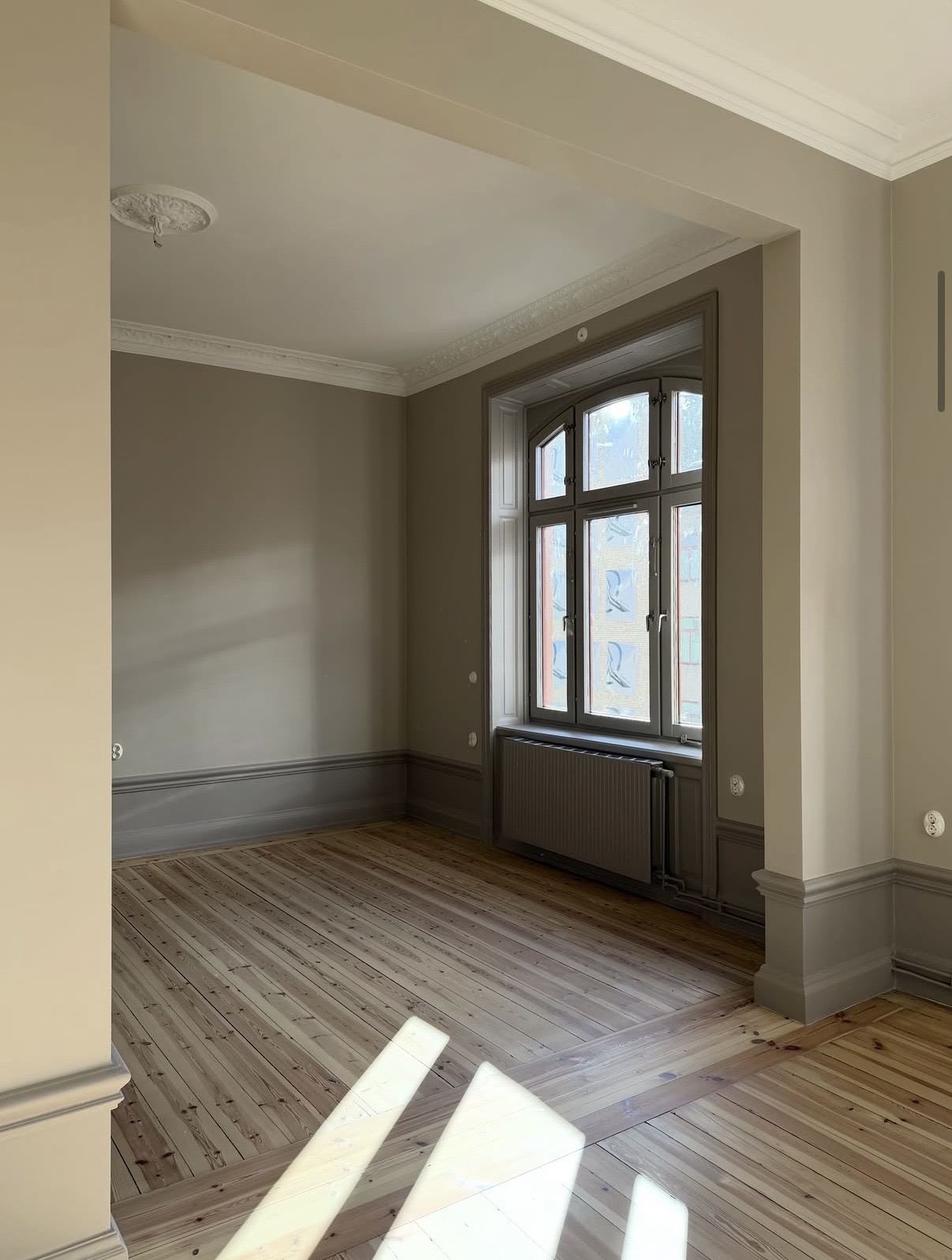 Fönsterparti med målade foder och radiatornisch